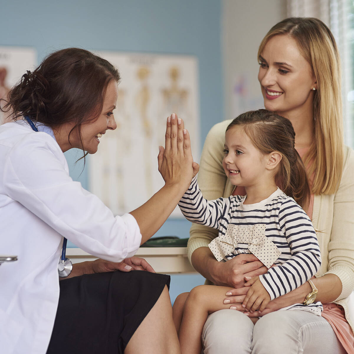 A clinician talking with a patient in an exam room